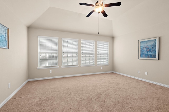 empty room featuring lofted ceiling, light carpet, and ceiling fan