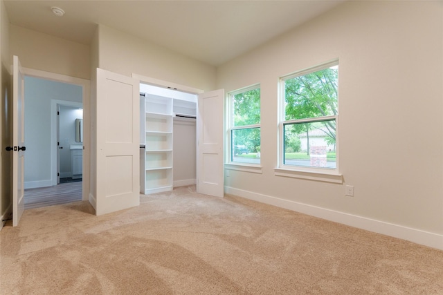 unfurnished bedroom with a closet and light carpet