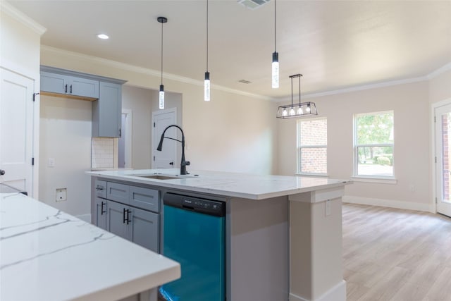 kitchen featuring decorative light fixtures, dishwasher, sink, light stone counters, and a center island with sink