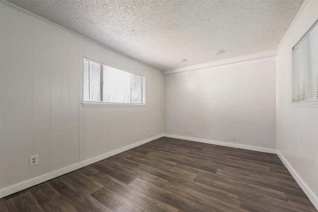 unfurnished room with crown molding, a textured ceiling, baseboards, and dark wood-type flooring