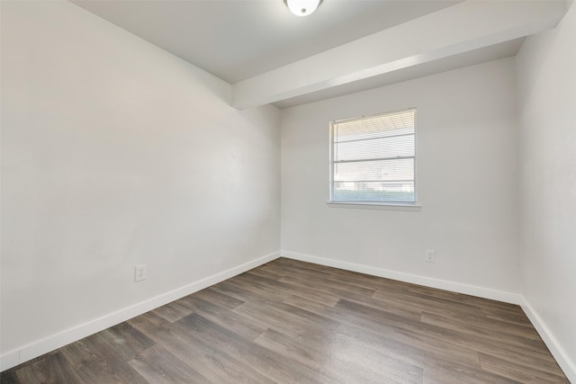 spare room featuring baseboards and wood finished floors