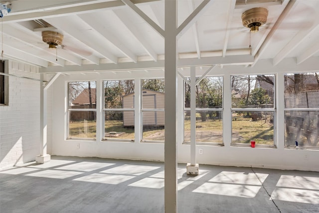 unfurnished sunroom featuring beamed ceiling