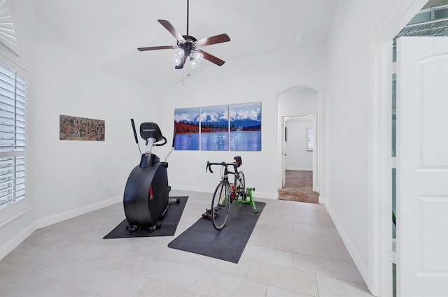 exercise room with light tile patterned floors, vaulted ceiling, a healthy amount of sunlight, and ceiling fan