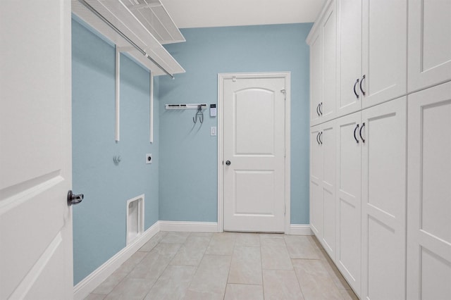 clothes washing area featuring cabinets, light tile patterned flooring, and hookup for an electric dryer