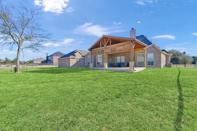 back of property with central air condition unit, a patio area, and a lawn