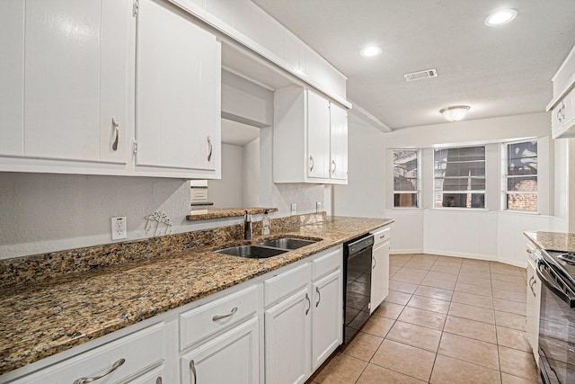 kitchen featuring sink, black appliances, dark stone countertops, light tile patterned floors, and white cabinets