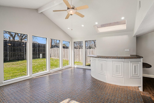 interior space featuring lofted ceiling with beams and ceiling fan