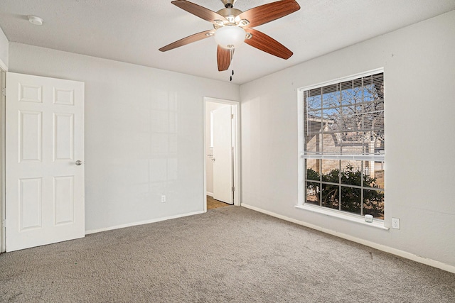 carpeted spare room featuring ceiling fan