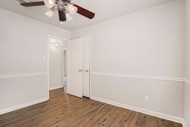 spare room with dark wood-type flooring and ceiling fan