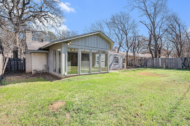 back of house with a yard and a sunroom