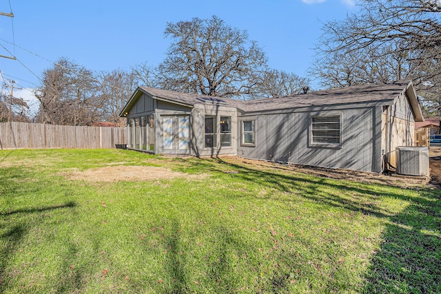 back of property featuring a yard and central AC