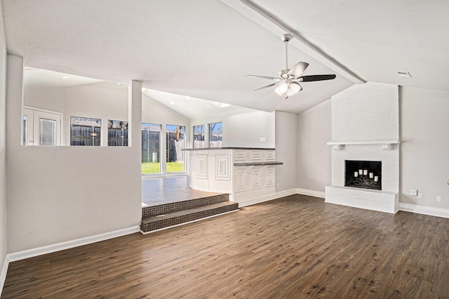 unfurnished living room featuring ceiling fan, vaulted ceiling with beams, dark wood-type flooring, and a fireplace