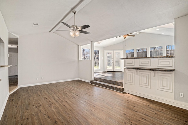 unfurnished living room featuring ceiling fan, vaulted ceiling with beams, dark hardwood / wood-style flooring, and french doors