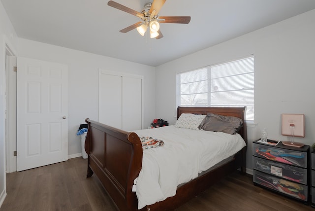 bedroom with dark wood-type flooring, ceiling fan, and a closet