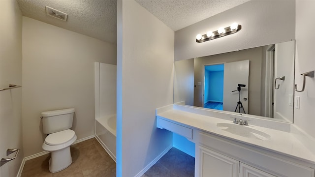 bathroom featuring vanity, a textured ceiling, and toilet