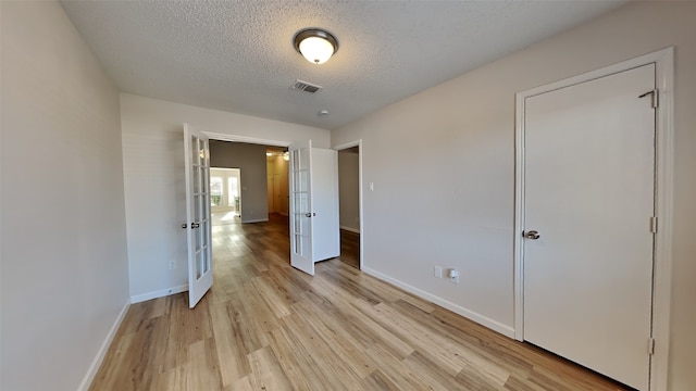 unfurnished bedroom featuring light hardwood / wood-style floors and a textured ceiling