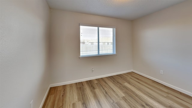 empty room featuring a textured ceiling and light hardwood / wood-style flooring