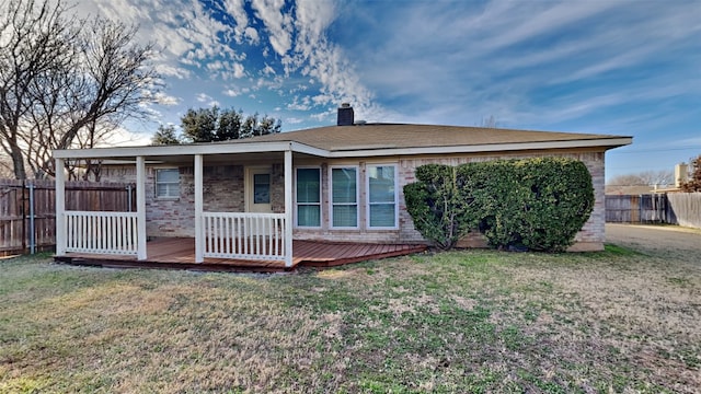 rear view of property featuring a deck and a lawn