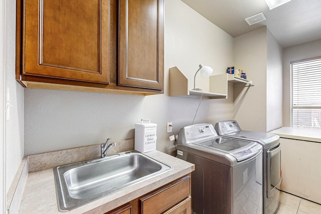 laundry area featuring cabinets, washing machine and dryer, sink, and light tile patterned floors