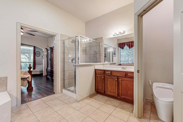 bathroom with tile patterned floors, toilet, a shower with shower door, vanity, and ceiling fan