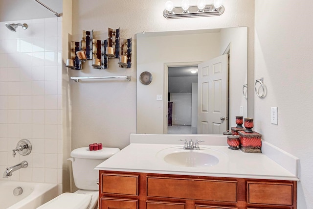 full bathroom featuring tiled shower / bath combo, vanity, and toilet