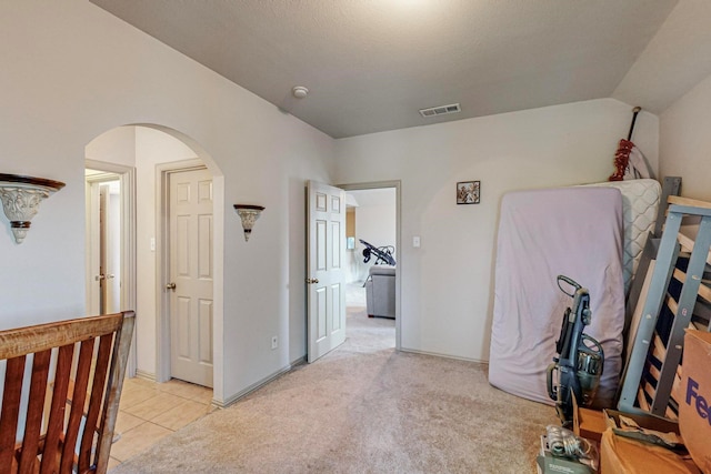 hall with lofted ceiling and light carpet