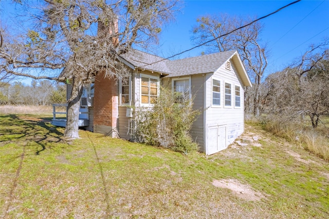 view of side of home with a yard