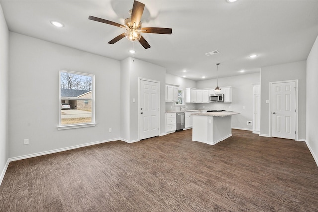 kitchen featuring white cabinetry, a center island, hanging light fixtures, ceiling fan, and stainless steel appliances