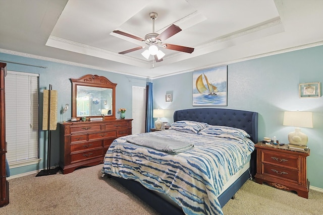 bedroom featuring a raised ceiling, ornamental molding, carpet floors, and ceiling fan