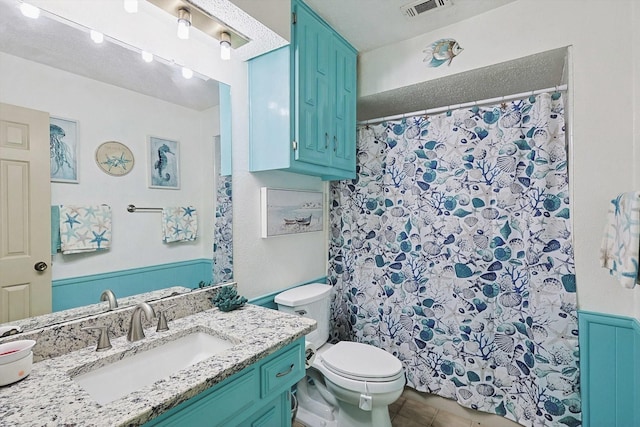 bathroom featuring vanity, tile patterned floors, and toilet