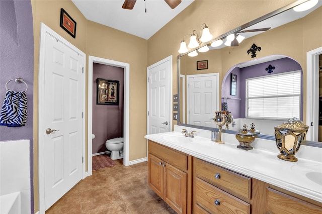 bathroom featuring vanity, tile patterned floors, ceiling fan, and toilet