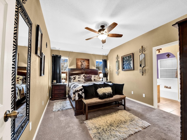 carpeted bedroom with a textured ceiling, ceiling fan, and ensuite bathroom