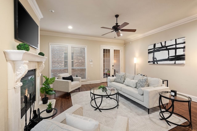 living room featuring wood-type flooring, crown molding, a fireplace, and french doors