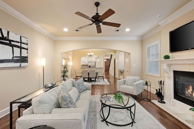 living room with hardwood / wood-style flooring, a fireplace, ornamental molding, and ceiling fan