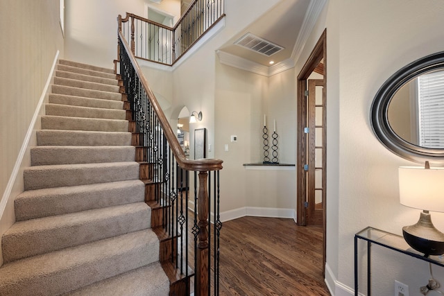 stairs featuring crown molding and wood-type flooring