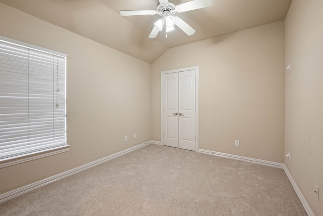 unfurnished room featuring lofted ceiling, light carpet, and ceiling fan