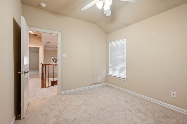 empty room featuring lofted ceiling, light colored carpet, and ceiling fan