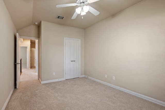 unfurnished bedroom with ceiling fan, lofted ceiling, and light carpet