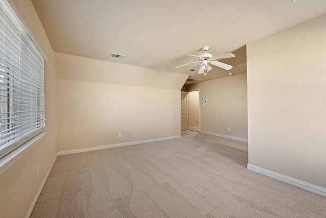 carpeted empty room with ceiling fan and lofted ceiling