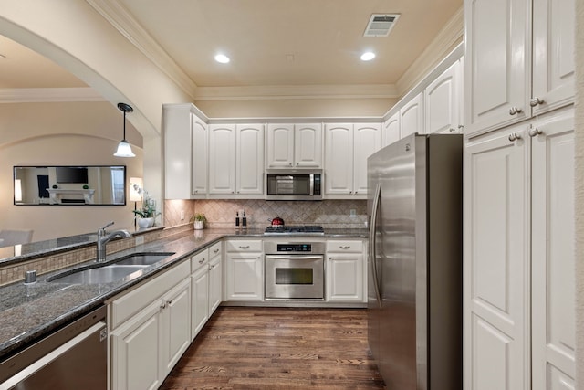 kitchen featuring stainless steel appliances, white cabinetry, sink, and dark stone counters