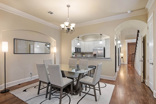 dining room with crown molding, wood-type flooring, and a chandelier