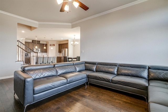 living room with crown molding, dark hardwood / wood-style flooring, and ceiling fan with notable chandelier