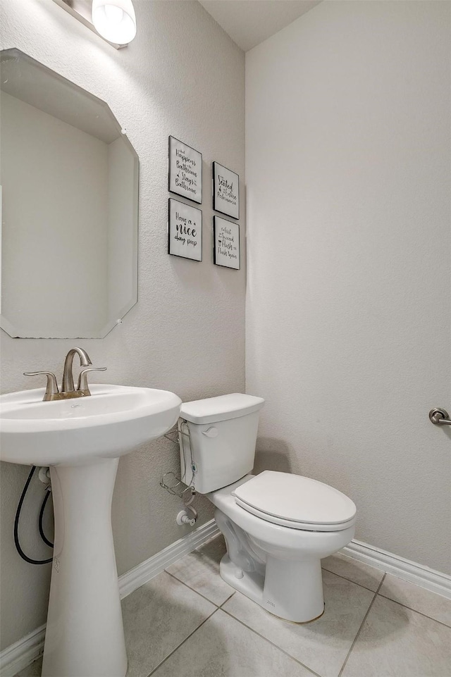 bathroom featuring tile patterned floors, toilet, and sink