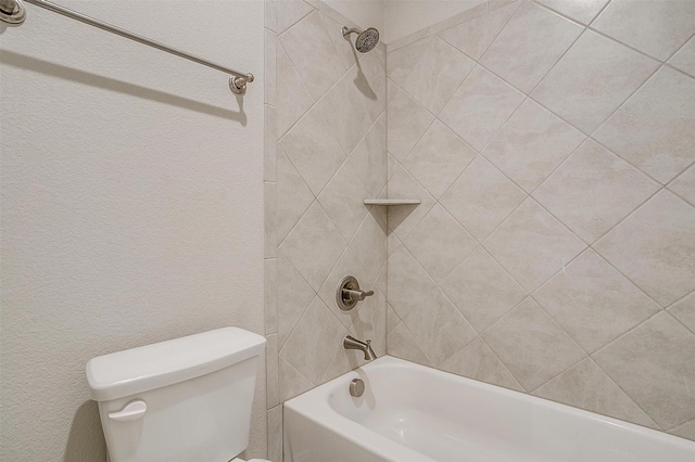 bathroom with toilet and tiled shower / bath combo