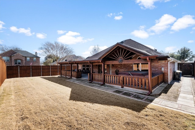 rear view of house featuring brick siding, a patio area, a shingled roof, and a fenced backyard