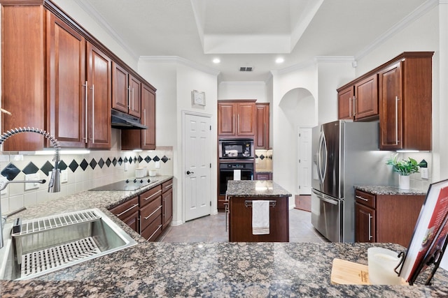 kitchen featuring tasteful backsplash, sink, dark stone countertops, a center island, and black appliances