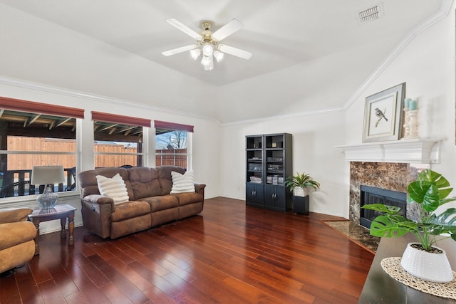 living room featuring visible vents, wood finished floors, a fireplace, ceiling fan, and vaulted ceiling