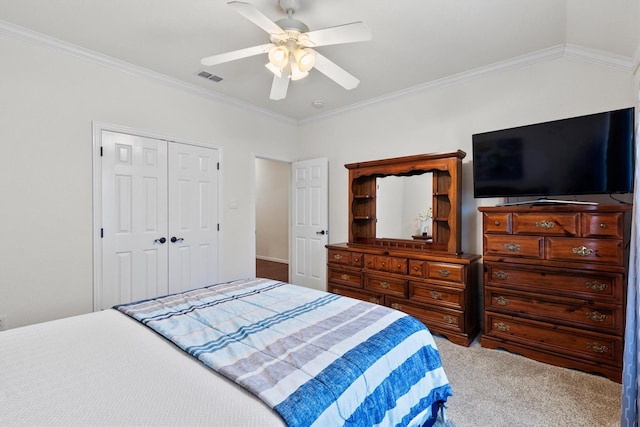 carpeted bedroom featuring ceiling fan, visible vents, a closet, and ornamental molding