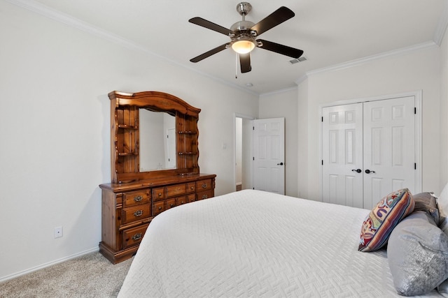 carpeted bedroom with visible vents, a closet, crown molding, baseboards, and ceiling fan