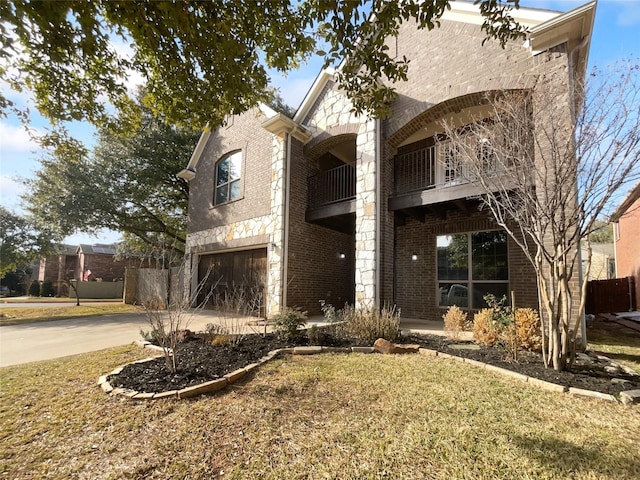 view of front of house featuring a balcony, a garage, and a front yard